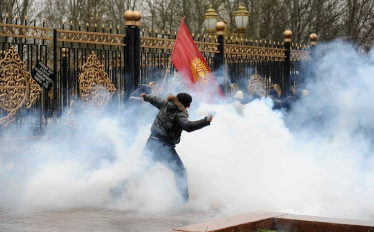Image: A protestor throws stones outside the presidential office in Bishkek, capital of Kyrgyzstan,