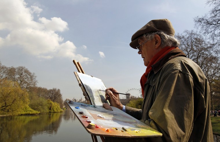 Image: An artist paints during a sunny spring day in a park in London