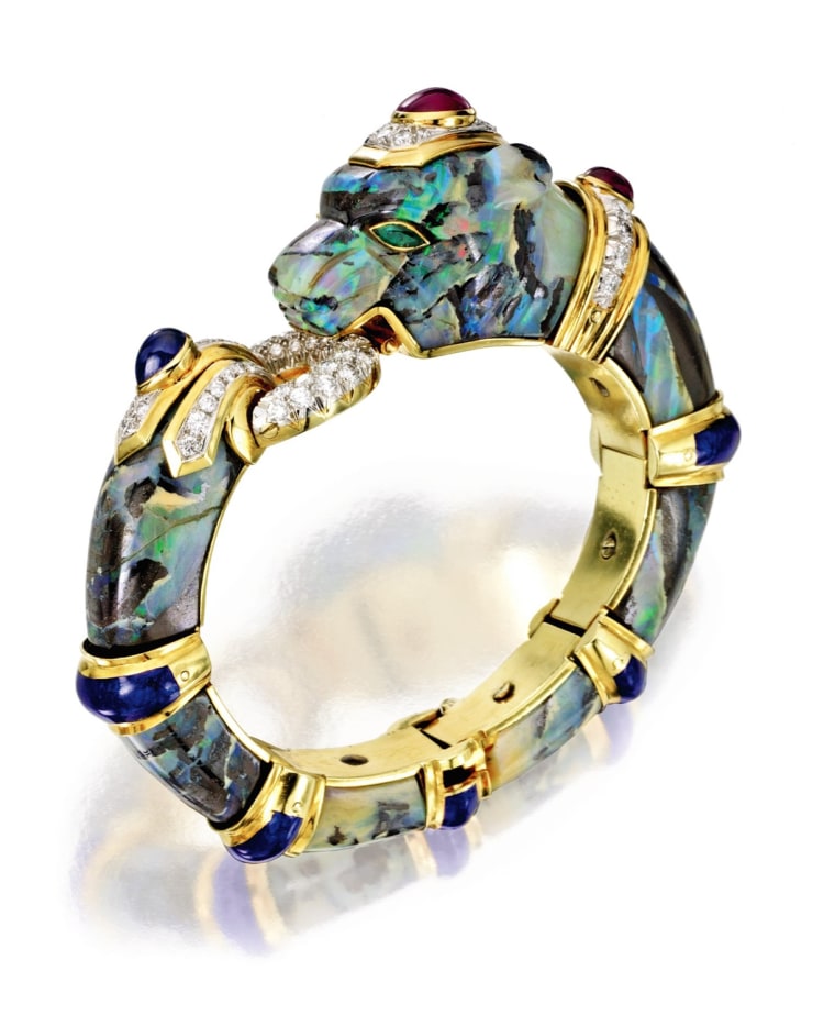 Property of a Private Collector
18 Karat Gold, Platinum, Boulder Opal, Enamel, Colored Stone and Diamond Panther Bangle-Bracelet, David Webb
Composed of carved boulder opal segments, accented by round diamonds weighing approximately 3.00 carats, cabochon rubies and sapphire, and marquise-shaped emerald eyes, applied with blue enamel
Est. $40/60,000