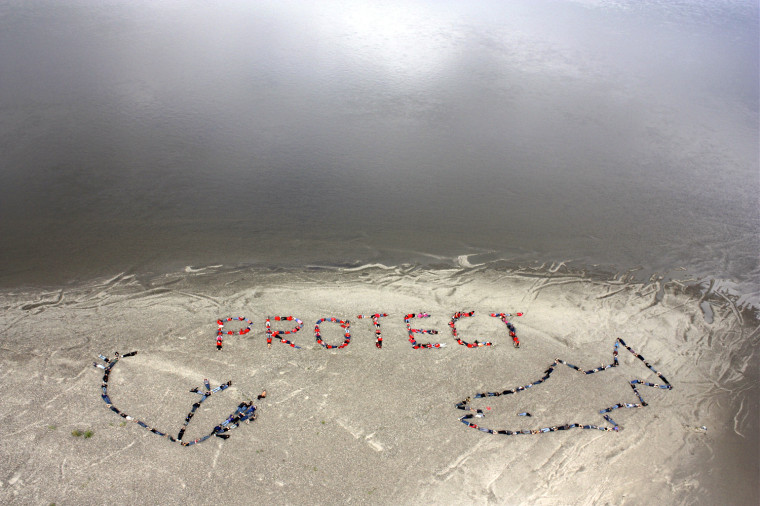 Image: Native people of the Gwich'in Nation form a human banner on the banks of the Porcupine River near Ft. Yukon, Alaska, in regard to the BP oil spill in the Gulf of Mexico