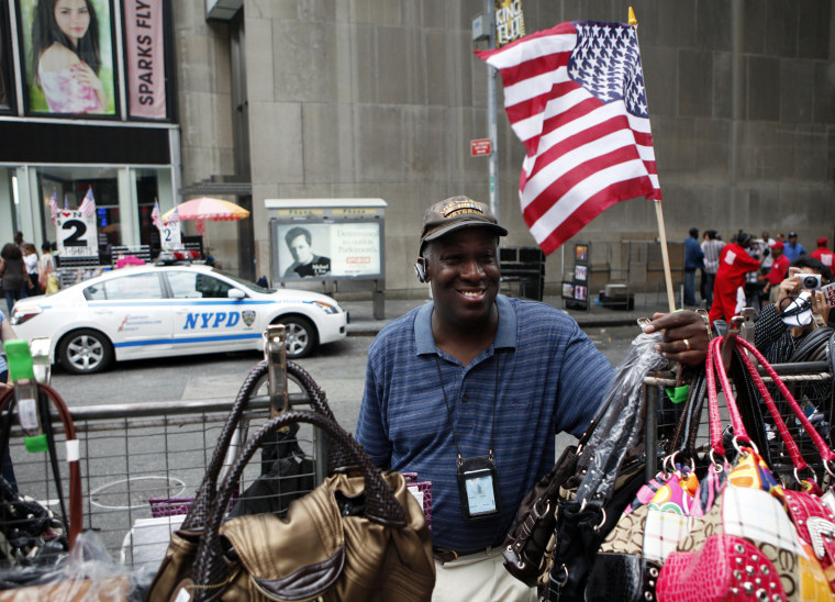 Image: Street vendor Jackson stands at his table a day after an alleged homemade bomb was found in a car directly behind where he is standing in Times Square in New York