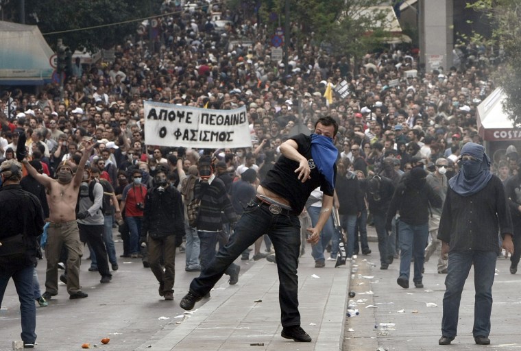 Image: Demonstrators hurl projictiles at riot police during nationwide strike over austerity measures in Athens