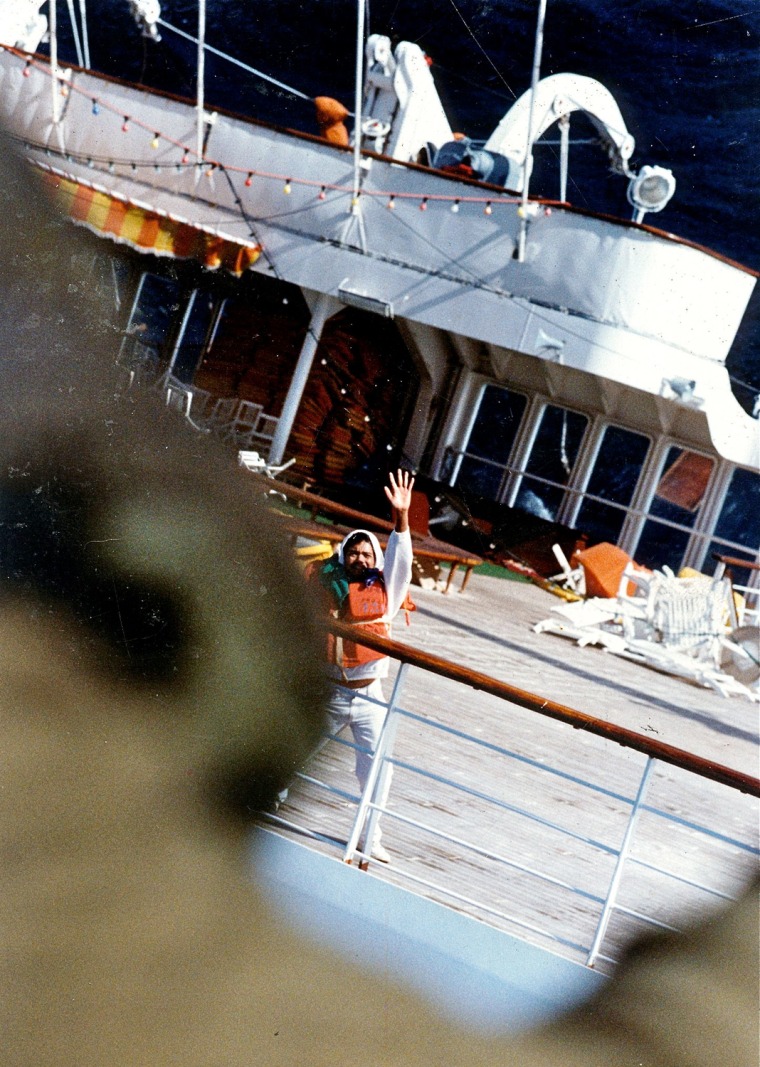 A member of the crew signals the chopper from the rear deck.