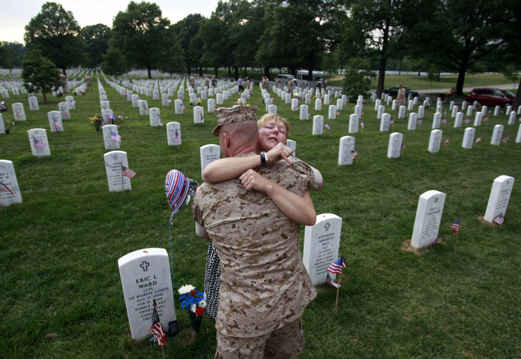 Image: Monica McNeal hugs a U.S. Marine at the grave of her son Eric Ward at Arlington National Cemetery