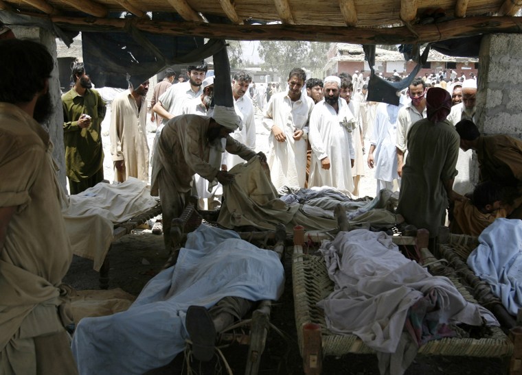 Image: A man searches for a family member among the corpses retrieved from the aftermath of a suicide bomb blast in Pakistan's northwestern Mohmand region