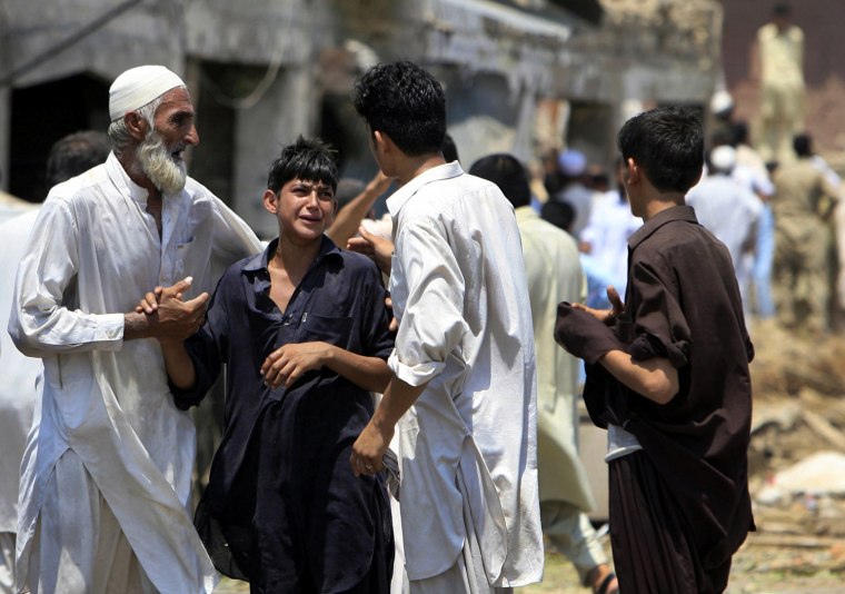Image: A man consoles a boy at the site of a suicide bomb blast in Pakistan's northwestern Mohmand region