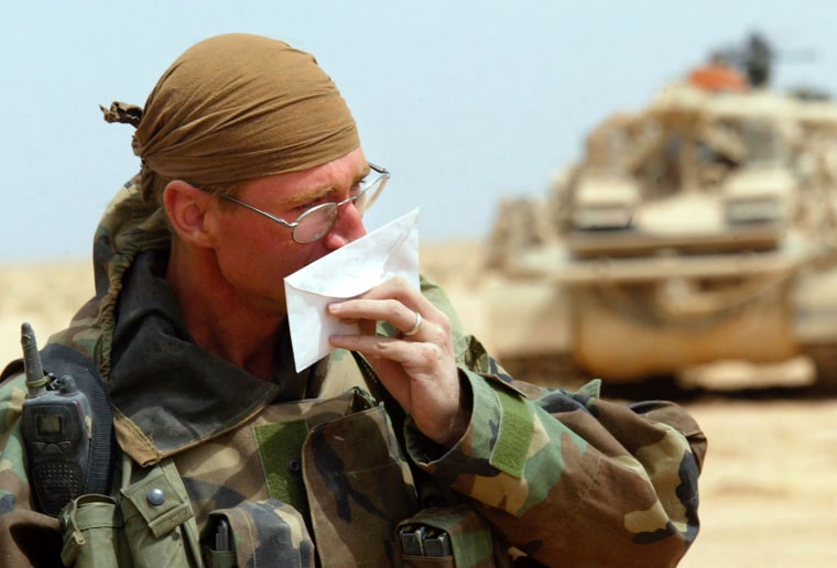 U.S. Army Spc. Lucas Edwards, in the A Company 3rd Battalion 7th Infantry Regimentpart of the 3rd Infantry Division, smells the perfume on mail sent from his wife Stephanie,  in the desert near Karbala in central Iraq Saturday, March 29, 2003. As some units on the field  have been ordered an operational pause for a chance to resupply, U.S.-led coalition aircraft and missile strikes continue over Iraq in operation \"Iraqi Freedom.\" (AP Photo/John Moore)