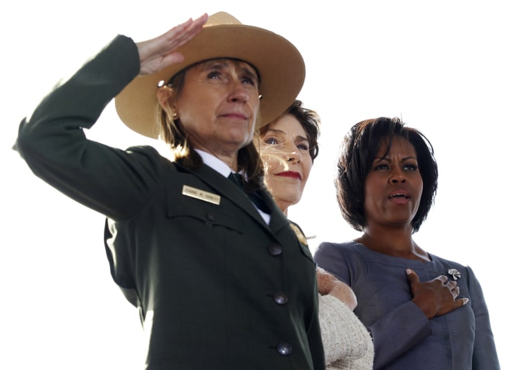 Image: Superintendent Joanne Hanley of the Flight 93 National Memorial salutes next to Former First Lady Laura Bush and First Lady Michelle Obama