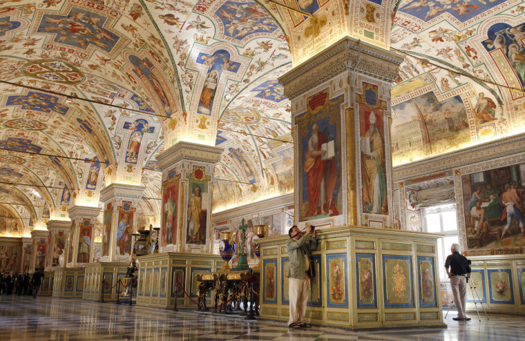 Image: Photographer takes a picture of the Sistine Hall, part of the renovated Vatican Apostolic Library, during its unveiling at the Vatican