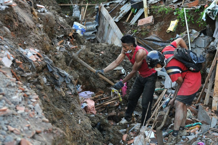 Image: Local residents remove rubble seeking fo