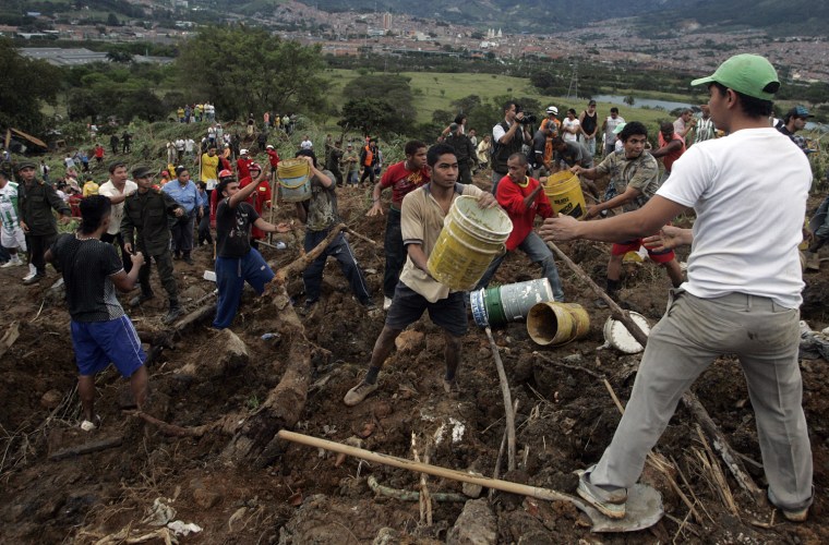 Image: Rescuers, soldiers, policemen and locals remove rubble following a landslide in Bello municipality in Antioquia province
