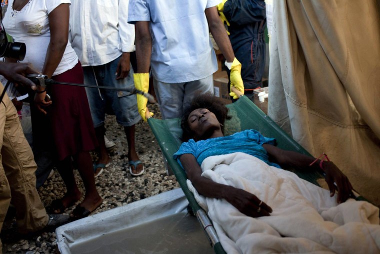 Image: A woman suffering from cholera symptoms lies on a stretcher at Santa Catherine hospital, Cite Soleil district, Port-au-Prince, Haiti