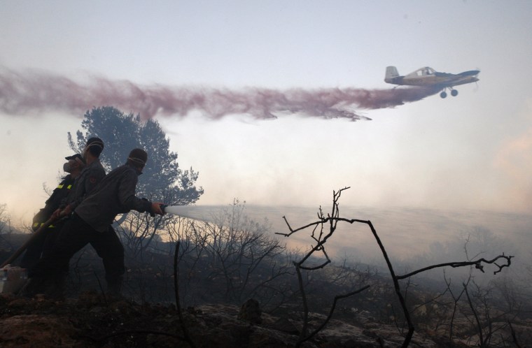 Image: Israeli firefighters put out the massive forest fire that broke out Thursday in the Tirat HaCarmel
