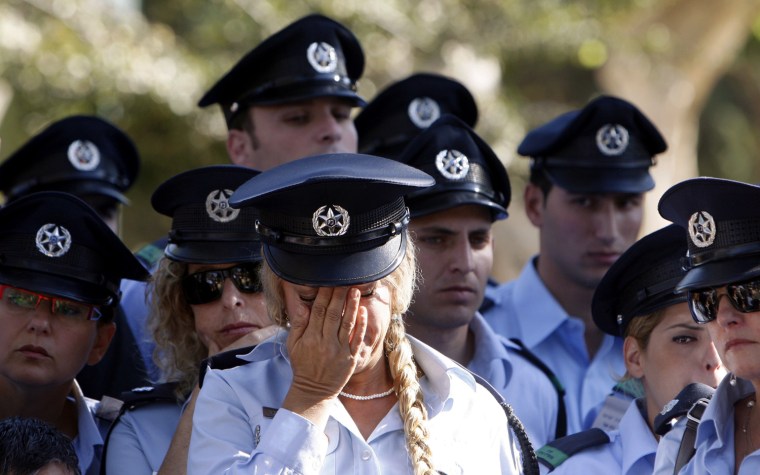 Image: Israeli police officers mourn during the funeral of their comrade Yitzhak Melina in Haifa