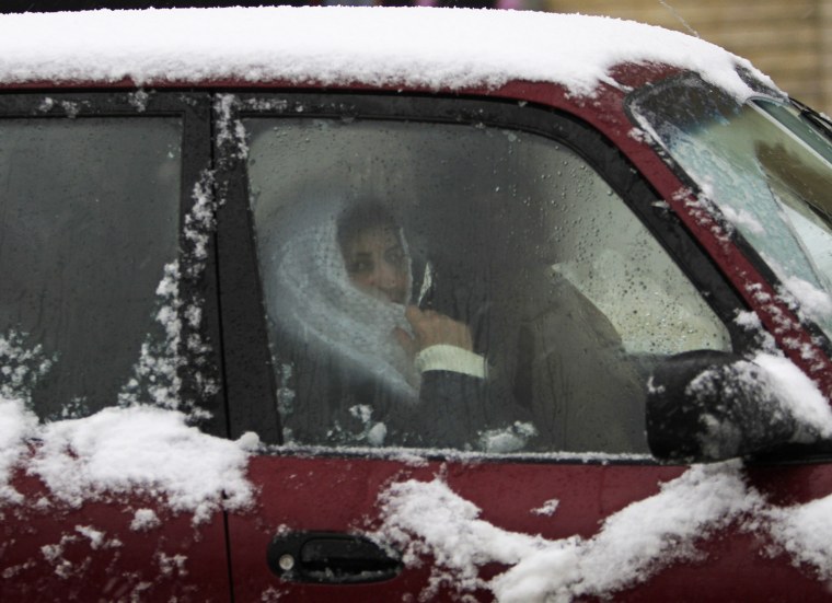Image: A woman looks through a car window covered with snow after a snow storm hit Bahamdoun village in eastern Lebanon