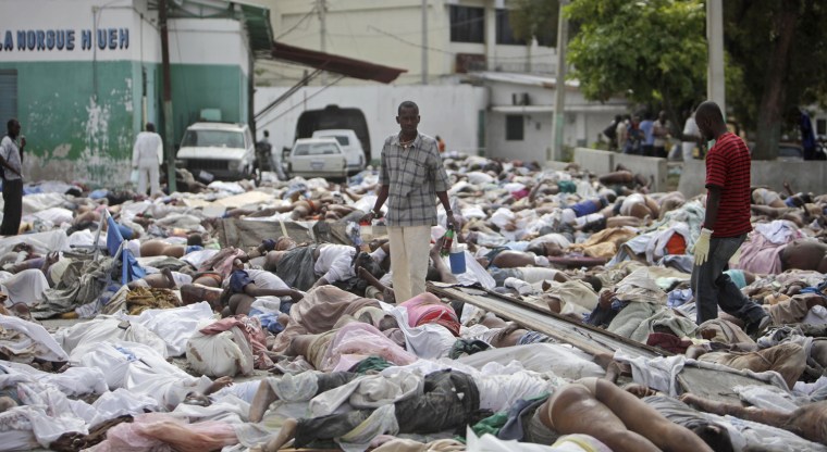 Image: A man surveys hundreds of bodies of earthquake victims
