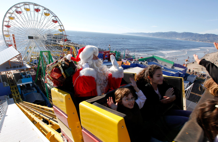 Image: Visitors ride along with a man dressed as Santa Claus on the roller coaster at Pacific Park