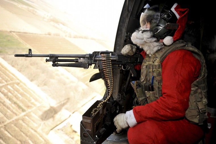 Image: Door Gunner Petty Officer Richard Symonds of the Royal Navy wears a Santa Claus outfit around Helmand province