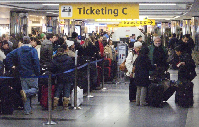 Image: Travelers wait in ticketing lines at New