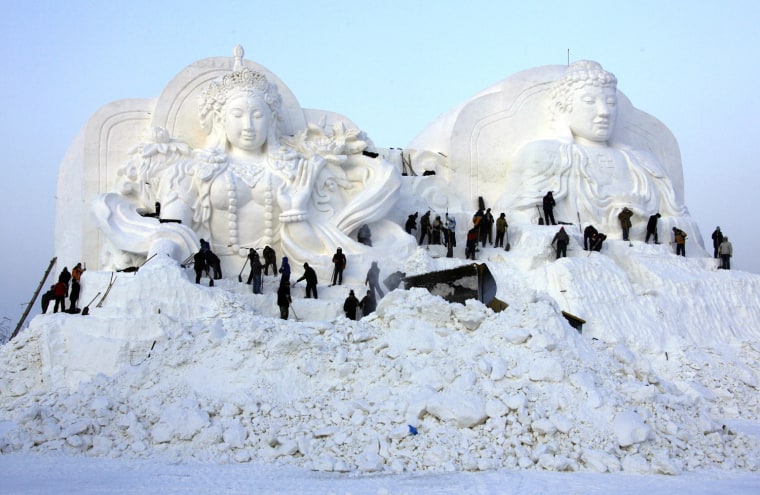 Image: Workmen put the finishing touches to a large snow sculpture at the 12th Harbin Ice and Snow World display in the northern city of Harbin