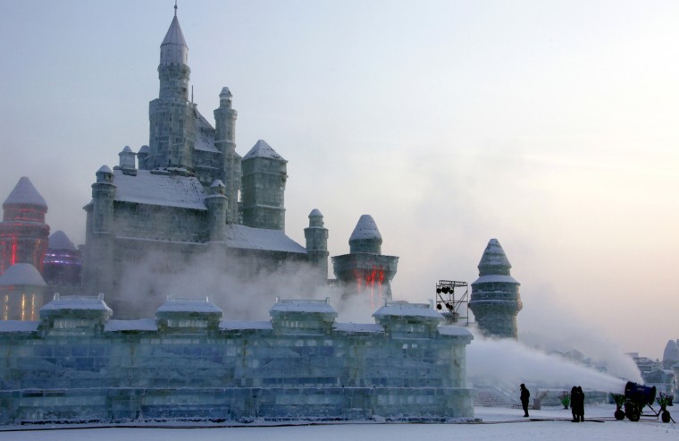 Image: Workmen put the finishing touches to an ice sculpture of a castle at the 12th Harbin Ice and Snow World display in the northern city of Harbin