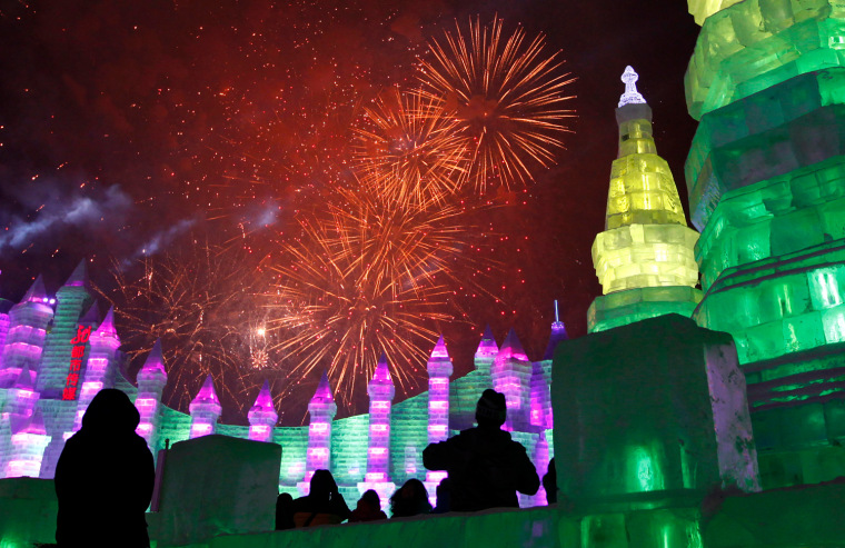 Image: Spectators watch fireworks explode over ice sculptures at the 12th Harbin Ice and Snow World display, during the official opening of the Harbin International Ice and Snow festival