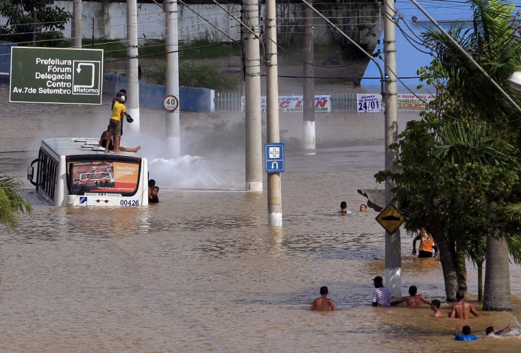 Image: People play in a flooded street in the center of the city of Franco da Rocha