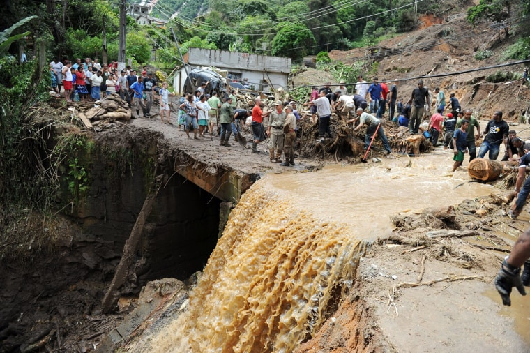 Image: Rescue workers search for victims after after heavy rains caused mudslides in a low-income neughbourhood in Teresopolis