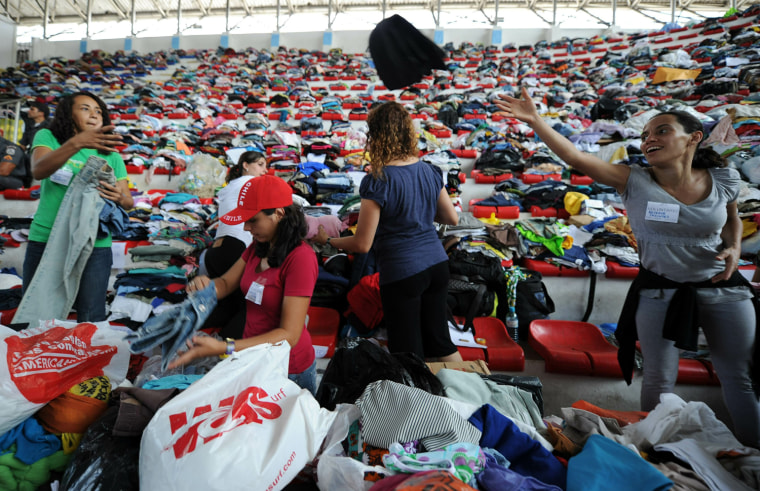 Image: Red cross volunteers stack donated cloth