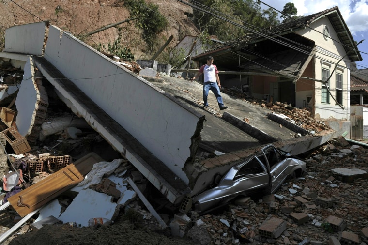 Image: A resident comes down a house destroyed