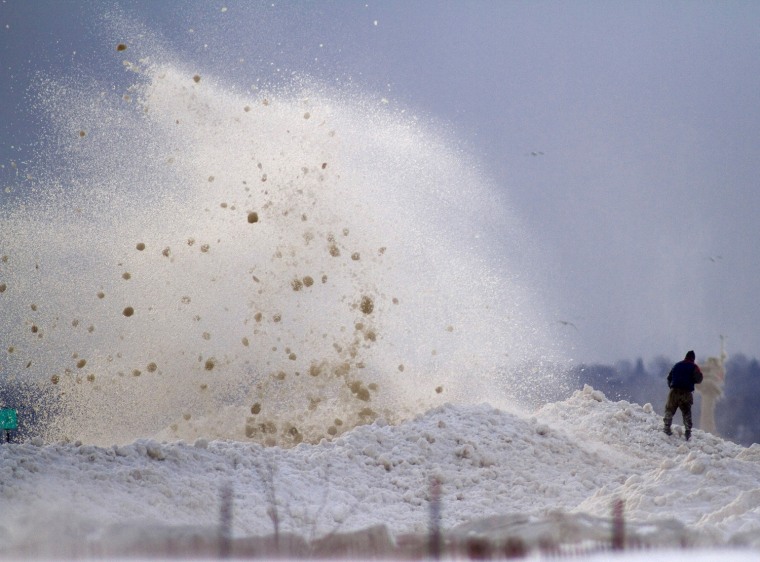 Image: A man watches as large chunks of ice crash into the break wall at the Milwaukee Marina in Wisconsin