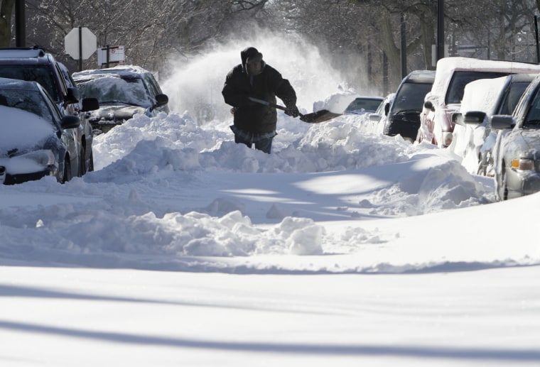 Image: Robert Brigs shovels snow at Martin Luther King Drive in Chicago