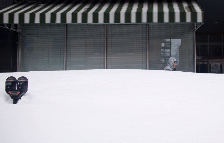 Image: A man walks behind high snowdrift in Racine County, Wisconsin