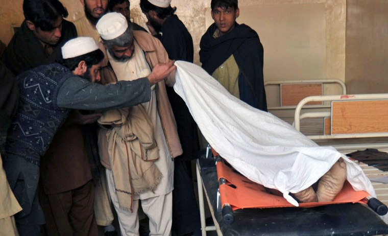 Image: Pakistani men attempt to identify a body