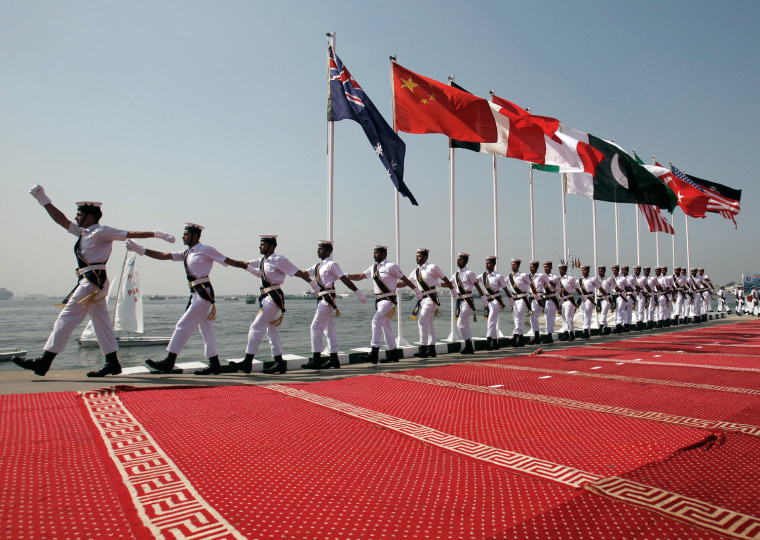 Image: Pakistani naval flag hosting team march past flags of participating countries during a flag hosting ceremony of the multination naval exercise Aman 11 in Karachi