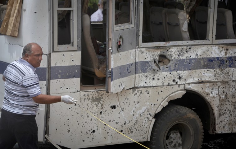 Image: A security official surveys the site of a roadside bomb attack in Karachi