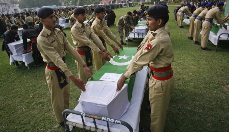 Image: Army soldiers stand over the coffins of Frontier Corps personnel before their funeral prayers in Peshawar, Pakistan