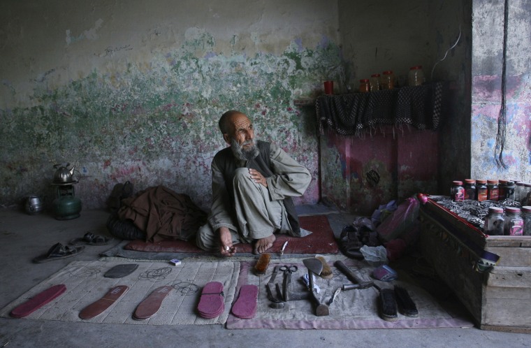 Image: A cobbler waits for customers at his shoe repair shop in Quetta