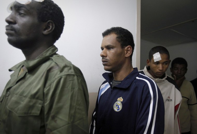 Image: Suspected African mercenaries stand in a room in a court as they are held by anti-government protesters, in Benghazi