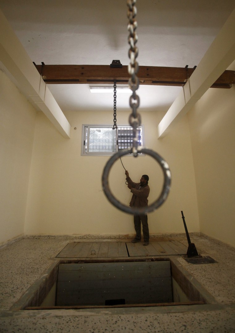Image: A man checks the execution room inside the burnt main prison of Libyan Muammar Gaddafi's forces in Benghazi