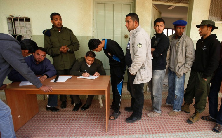 Image: Civilians who have volunteered to join the rebel army register their names in a school in Benghazi