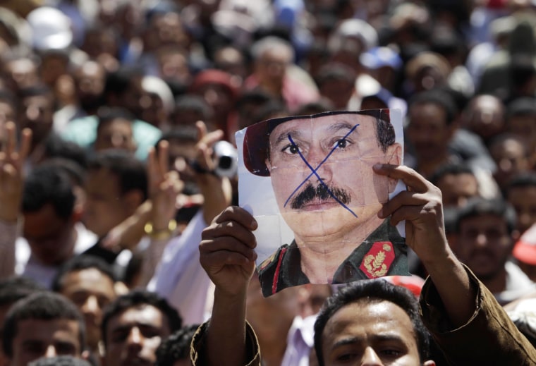 Image: A protester holds up a picture of Yemeni President Ali Abdullah Saleh as he shouts slogans during an anti-government rally outside Sanaa University