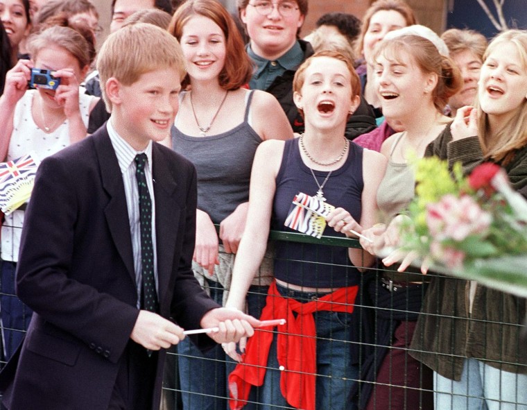 Prince Harry walks past cheering teenage girls int