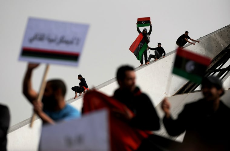 Image: Libyans wave their old national flag as