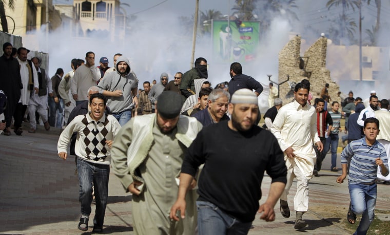 Image: Anti-Gadhafi protesters run from tear gas fired by police as they tried to disperse the demonstration in the Tajoura district of eastern Tripoli, Libya