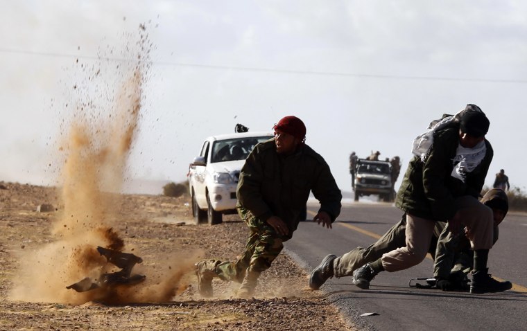 Image: Rebel fighters jump away from shrapnel during heavy shelling