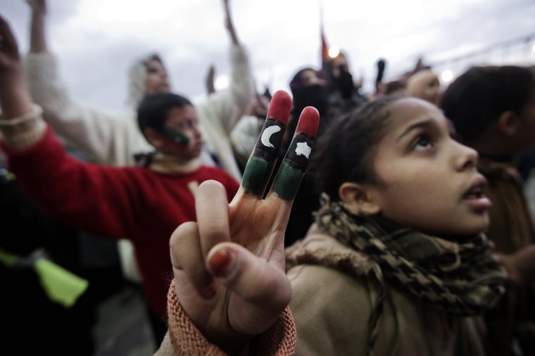 Image: A young Libyan girl flashes the \"V sign\"