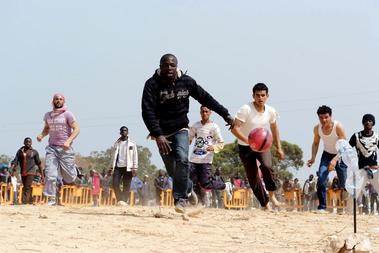 Image: Foreign evacuees  play soccer at a refugee camp near the Libyan and Tunisian border crossing of Ras Jdir