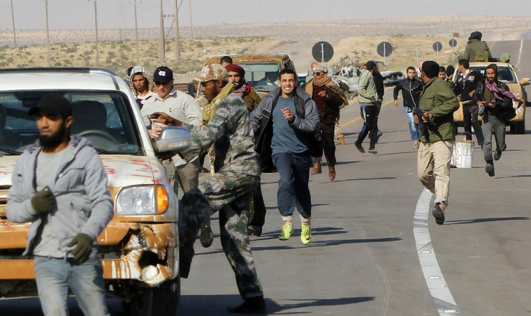 Image: Libyan rebels run for cover from artille
