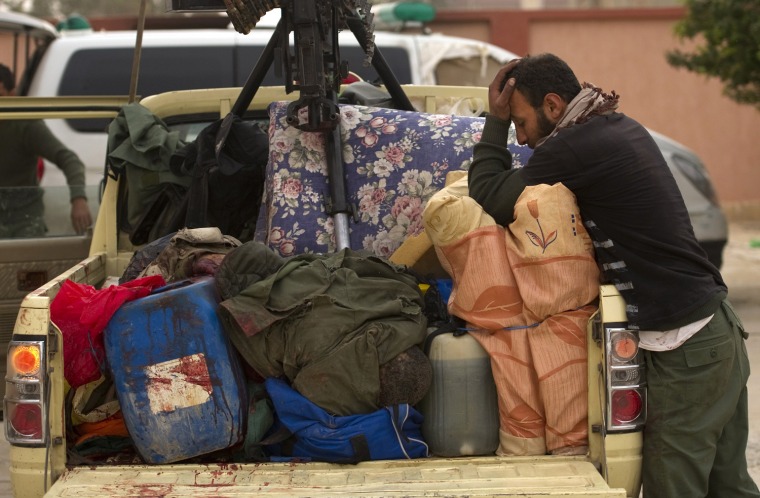 Image: A Libyan rebel fighter (R) mourns over a